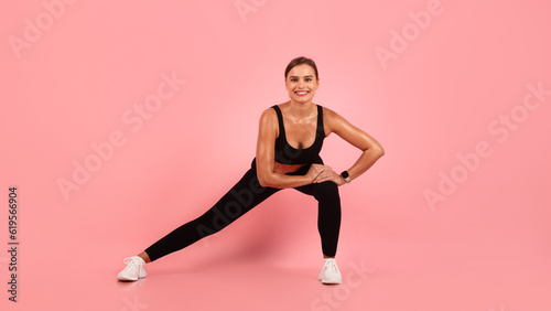Fitness Routine. Smiling Sporty Woman Doing Side Lunge Exercise On Pink Background