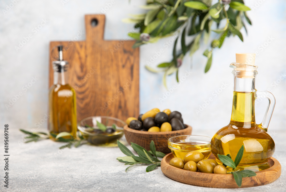 Olive oil in a bottle on a white texture background. Oil bottle with branches and fruits of olives. Place for text. copy space. cooking oil and salad dressing Olive oil in a bottle on a white texture background. Oil bottle with branches and fruits of olives. Place for text. copy space. cooking oil and salad dressing