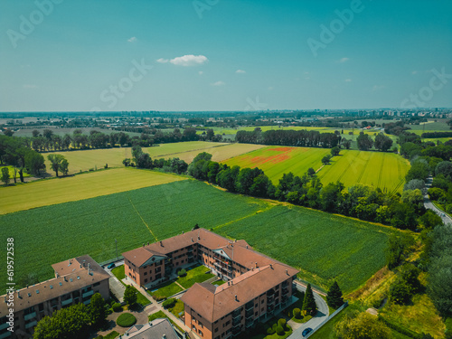 Fototapeta Naklejka Na Ścianę i Meble -  aerial view of the endless lush pastures and farmlands of Italy. Beautiful Italian countryside with emerald green fields and meadows
