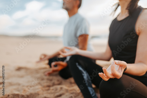 Calm senior caucasian couple in sportswear practice yoga and breathing exercises enjoy peace on beach