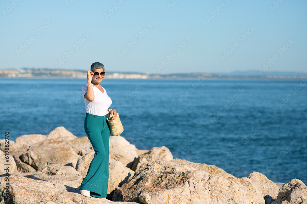 European Lady With Gray Hair Posing Wearing Sunglasses At Seaside
