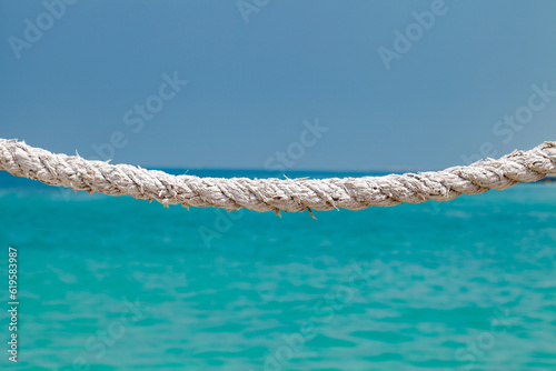 Rope old, cable-stayed rigging on background of blue sea and sky, selective focus