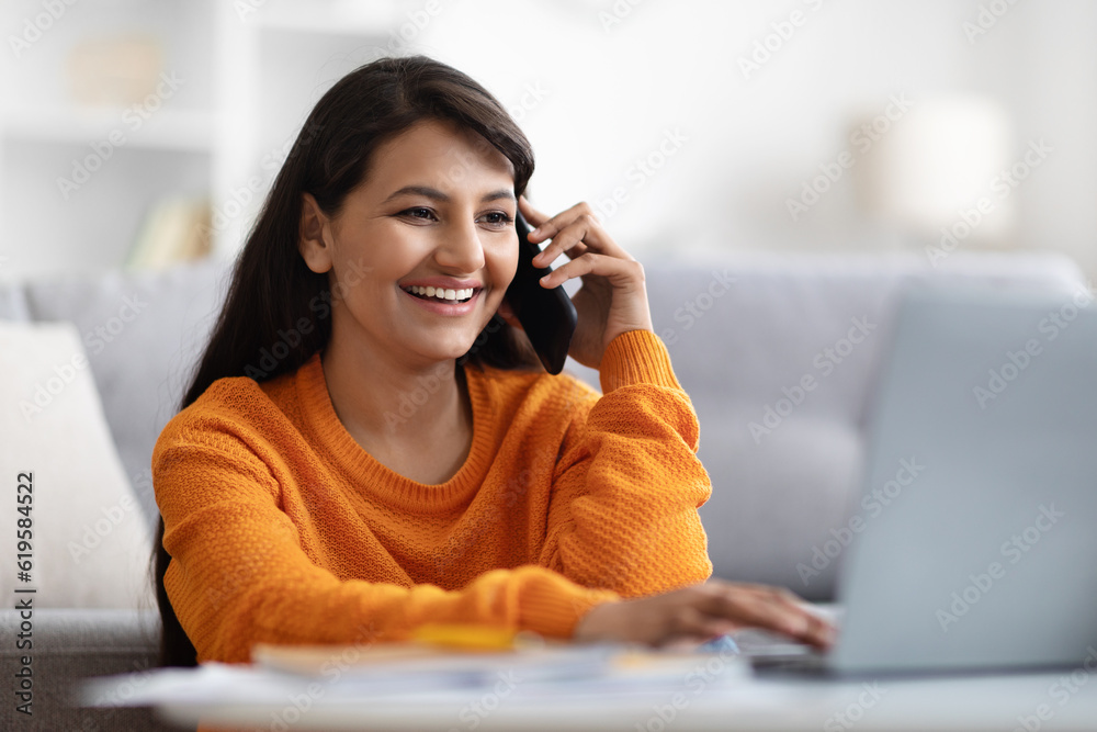 Closeup of indian woman entrepreneur using laptop and phone Closeup of indian woman entrepreneur using laptop and phone