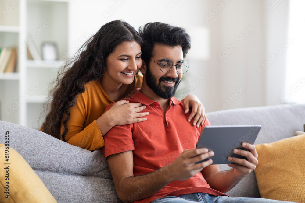 Happy Young Eastern Couple Using Digital Tablet Together At Home Happy Young Eastern Couple Using Digital Tablet Together At Home