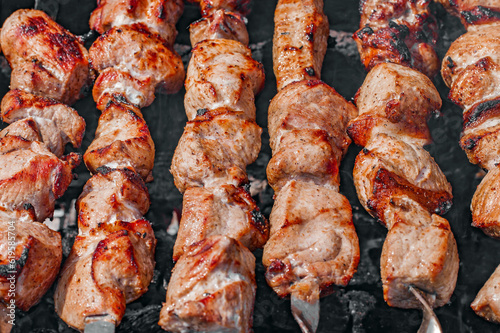 Meat with lard on skewers cooked in chunks on barbecue, close-up, selective focus