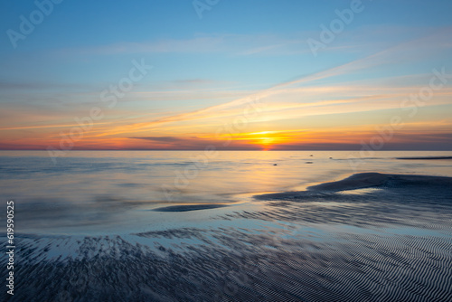Seascape at sunset. Blue hour. The last rays of the sun color the sky. The night is coming. Latvia. Baltic Sea. © Janis