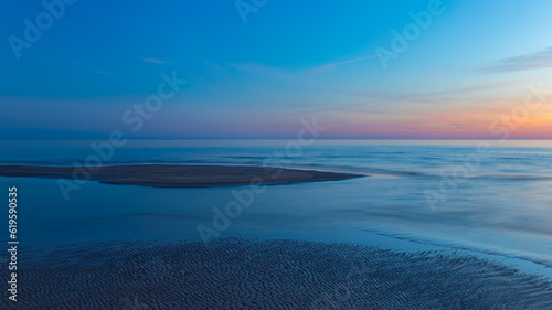 Seascape at sunset. Blue hour. The last rays of the sun color the sky. The night is coming. Latvia. Baltic Sea.