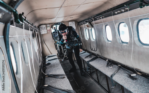 woman skydiver gives thumbs up before exiting empty airplane