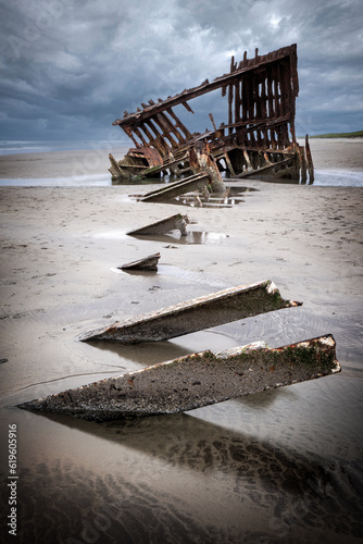 Rusted old shipwreck on sandy beach 