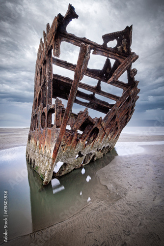 Rusted old shipwreck on sandy beach 