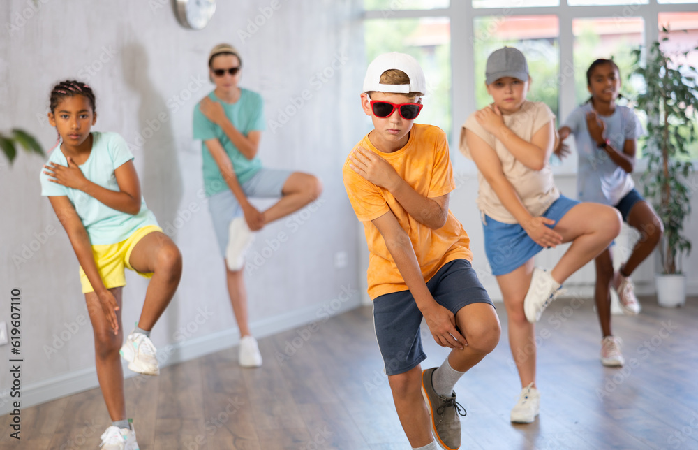 Smiling girls and boys doing dance workout during group class in fitness center