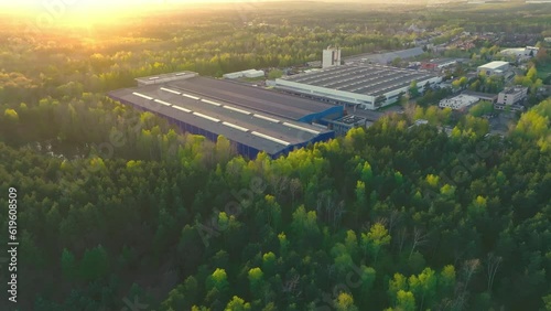 An industrial giant glows in the warmth of the setting sun. The aerial shot captures the magnitude of the building, surrounded by smaller structures.