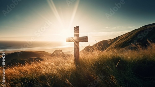 cross on a hill overlooking the ocean at sunset