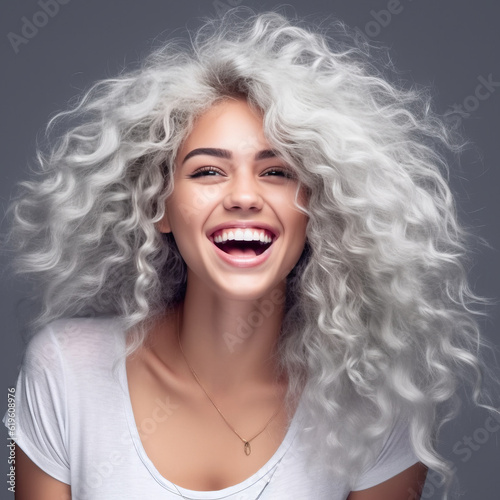Beautiful young woman with white long curly hair. Portrait of a happy beautiful blonde girl, studio shot. Beauty, fashion. Happy smiling women concept. Laughing young woman with healthy white teeth