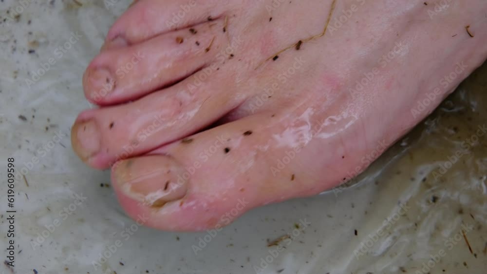 Slow motion and close up of bare toes and nails while splashing dirty water in container. Slow motion and close up of bare toes and nails while splashing dirty water in container.