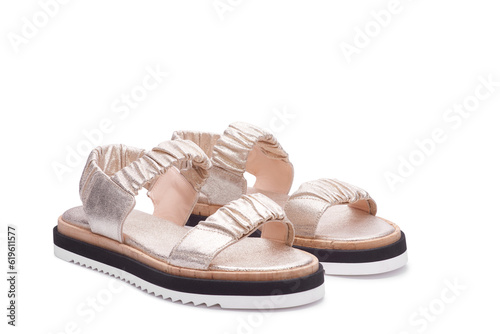 Metallic women's sandals from wrinkled leather isolated on white background.