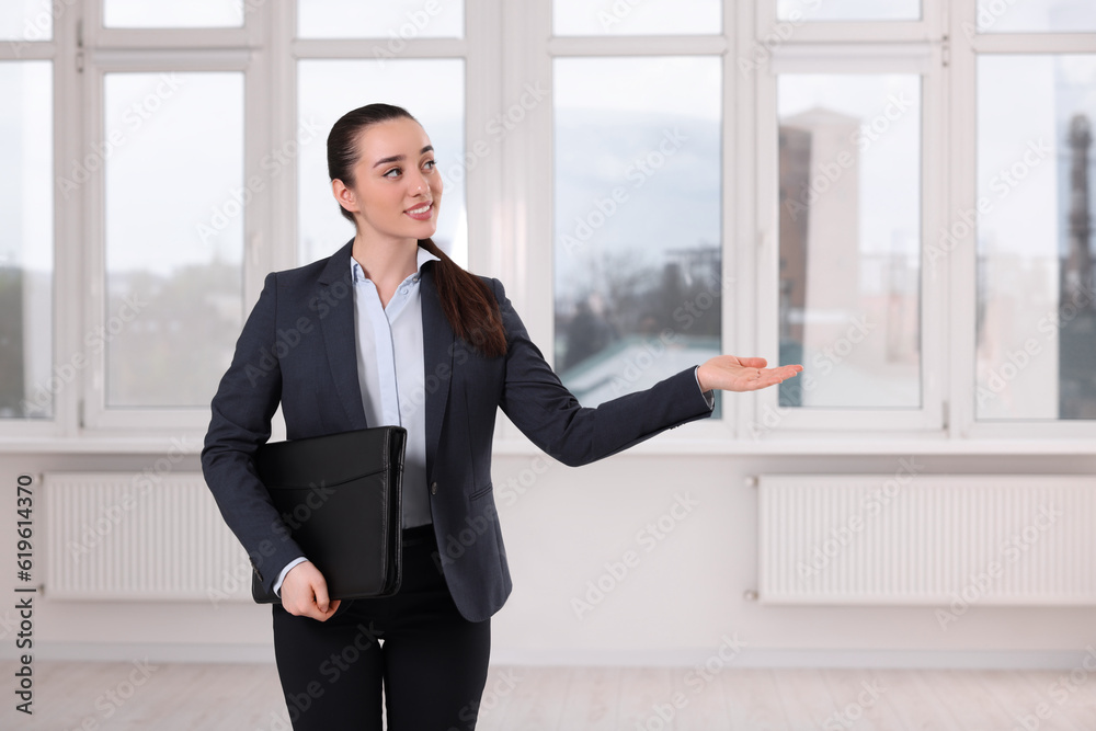 Happy real estate agent with leather portfolio showing new apartment Happy real estate agent with leather portfolio showing new apartment