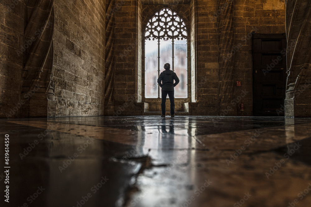 Spain, Valencia, Rear view of man looking through window in old empty church Spain, Valencia, Rear view of man looking through window in old empty church