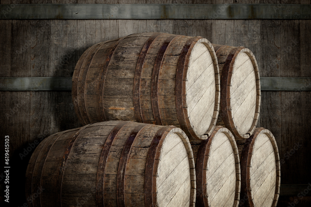 Many wooden barrels near dark textured wall