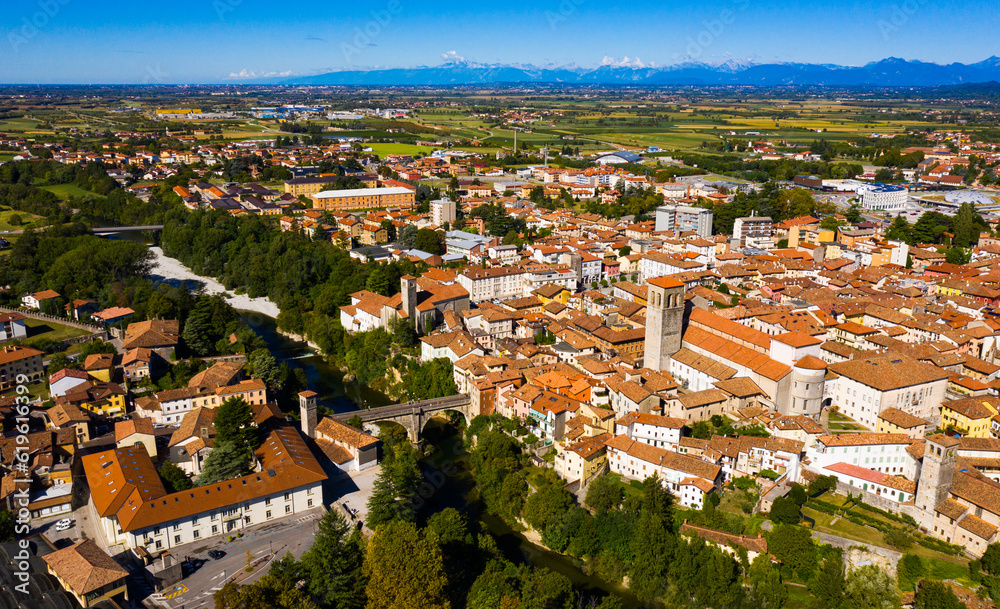 Aerial view of Cividale del Friuli cityscape on banks of Natisone river overlooking Catholic cathedral and ancient bridge Ponte del Diavolo, Italy..