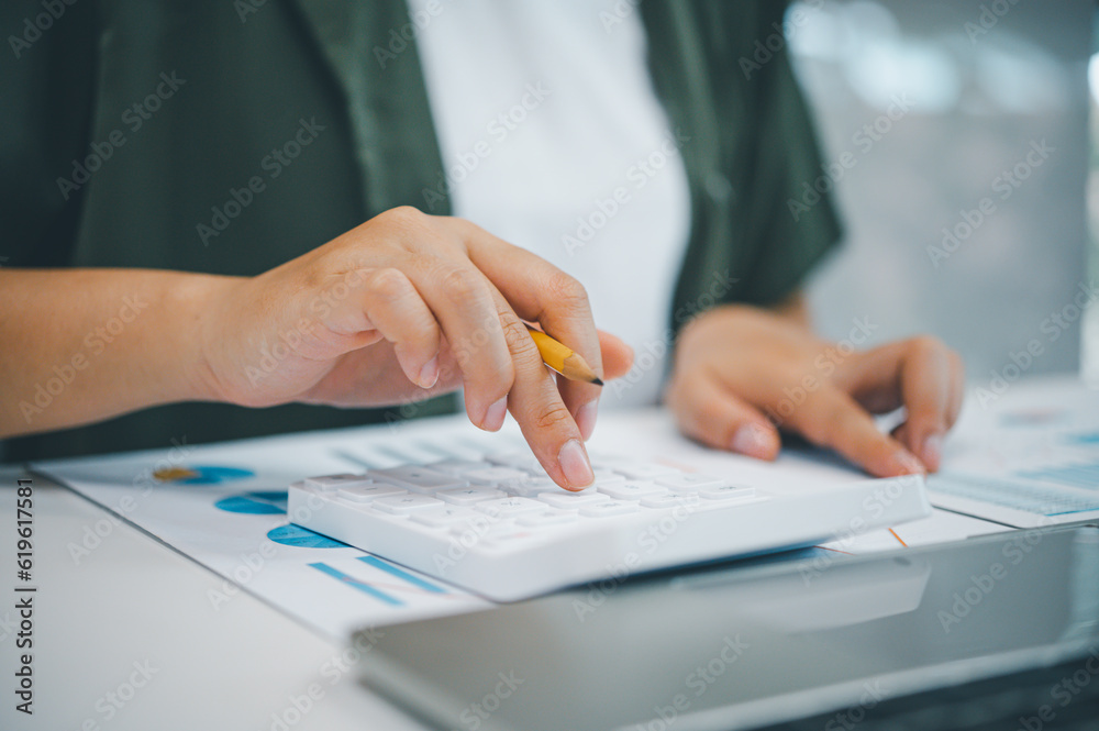 Fototapeta premium Freelance worker working on documents with graphs. and information about finances on laptops in cafes