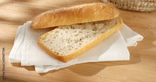 cut in half ciabatta bread on a napkin on a wooden background. Close up. Sunny day. High quality photo