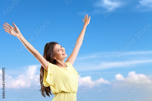 Beautiful young happy fit woman in front of blue sky