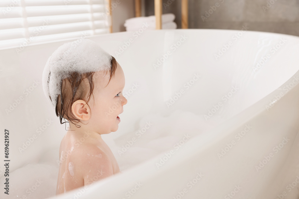 Cute little baby bathing in tub at home. Space for text Cute little baby bathing in tub at home. Space for text