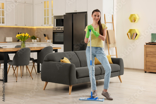 Spring cleaning. Young woman with mop washing floor at home