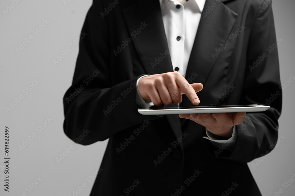 Closeup view of woman using modern tablet on grey background Closeup view of woman using modern tablet on grey background