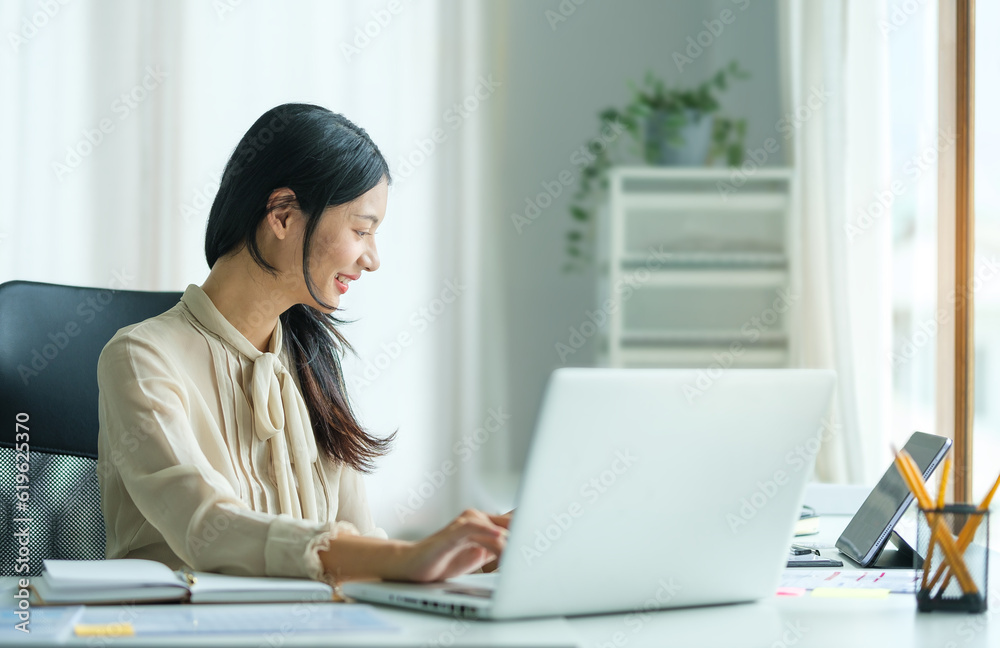 Portrait of happy young woman working on tablet pc while sitting at her working place in office. Portrait of happy young woman working on tablet pc while sitting at her working place in office.