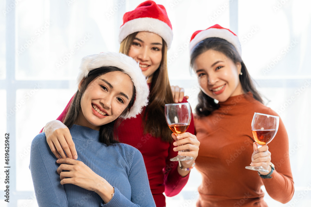 Cheerful friends enjoying birthday party at home Asian friend drinking red wine and smiling happily at a special occasion with her small office party. Cheerful friends enjoying birthday party at home Asian friend drinking red wine and smiling happily at a special occasion with her small office party.