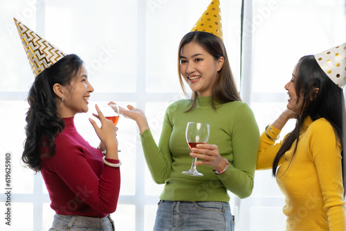 Photography Three beautiful girls wearing party hats are having fun celebrating their birthday in colorful tops
