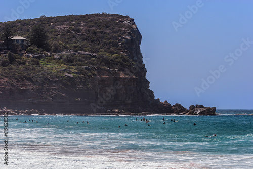 Surfers in the water near a headland