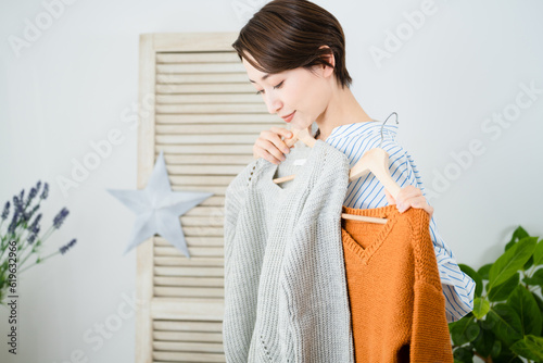 鏡の前で服選びをしている若い女性 ファッションイメージ 