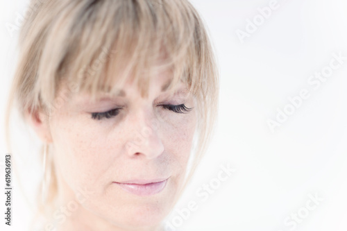 Photograph of a beautiful middle aged woman taken for a day spa photographed on white. 