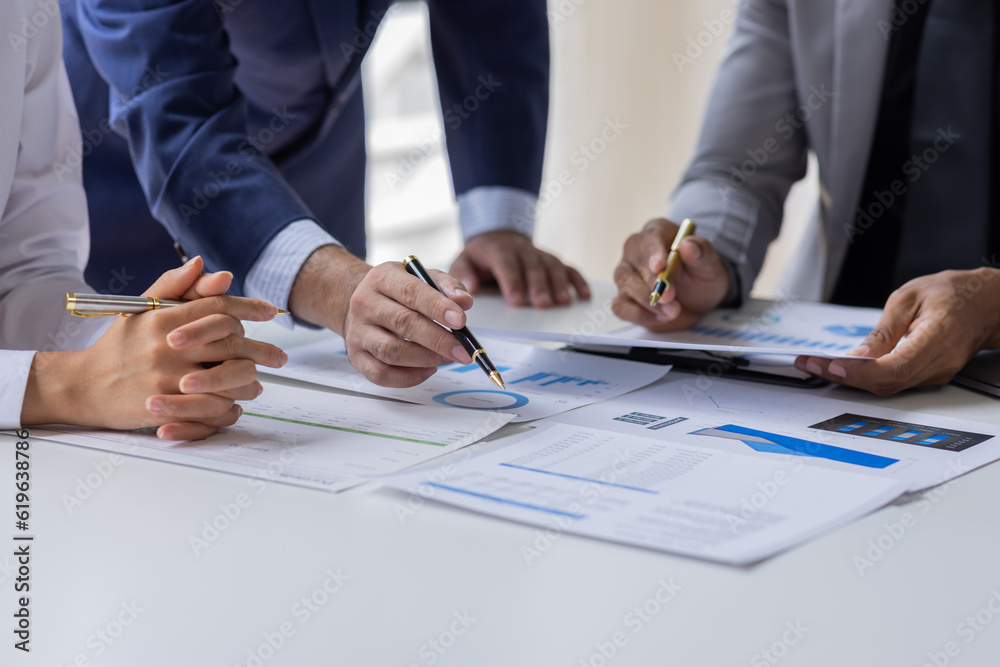 Group of confident business people point to graphs and charts to analyze market data, balance sheet, account, net profit to plan new sales strategies to increase production capacity. Group of confident business people point to graphs and charts to analyze market data, balance sheet, account, net profit to plan new sales strategies to increase production capacity.