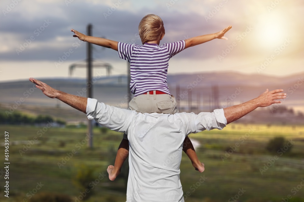 Happy child on father's neck play outdoor Happy child on father's neck play outdoor