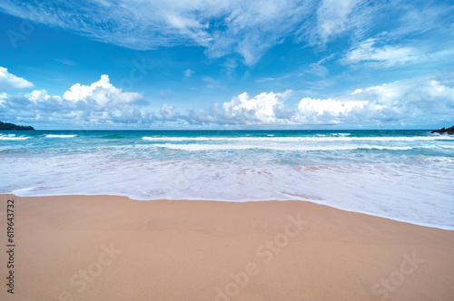 Beautiful sandy beach and sea waves crashing on sandy shore with clear blue sky background Amazing beach blue sky sun daylight relaxation landscape view Beach for Summer and travel background