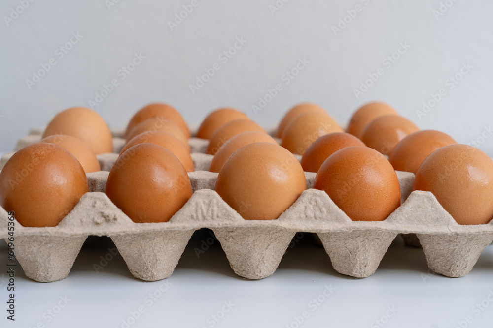 Raw chicken eggs in a cardboard tray, farm brown eggs background. Raw chicken eggs in a cardboard tray, farm brown eggs background.
