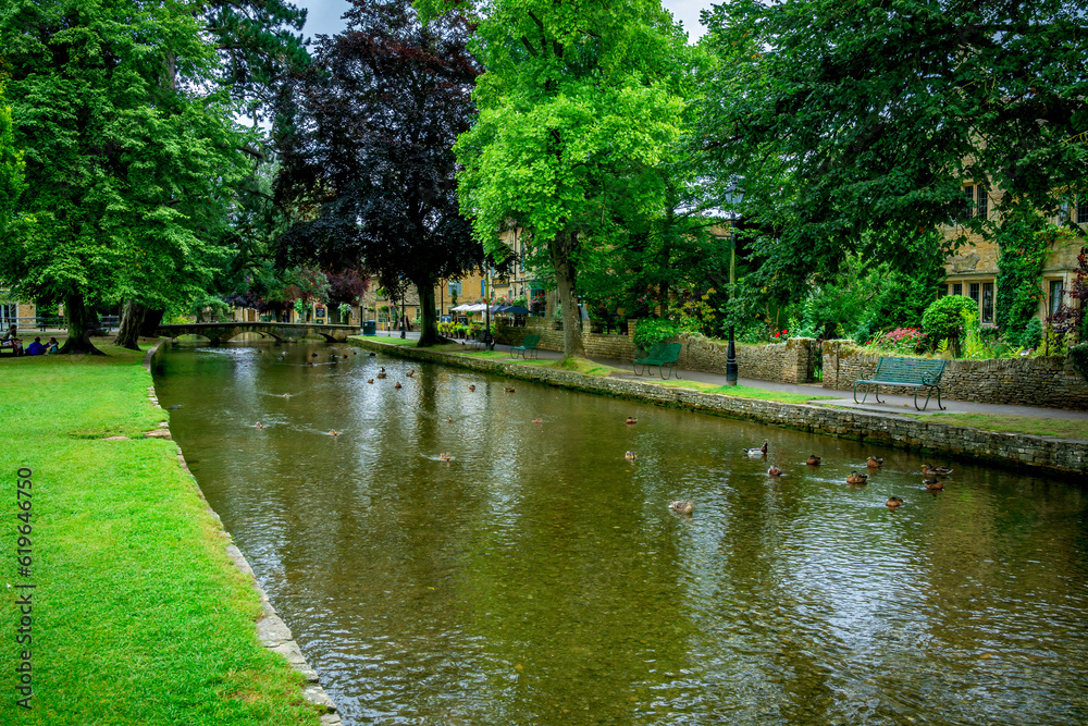River running through a park and village shops in the English countryside River running through a park and village shops in the English countryside