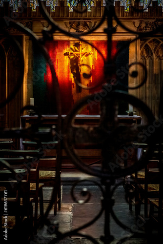 Crucifix on a church wall behind an iron gate