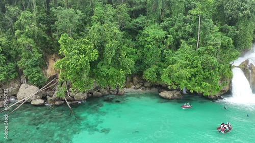 The scenic Momon waterfall tumbles from the primordial rainforest of West Papua into the shallow sea. This spectacular waterfall is found about a day's sail north of Kaimana.   photo