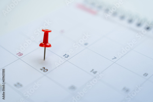 Close-up view of red pins with calendar for event planner event