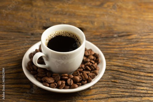 coffee cup with fresh coffee beans on wooden background