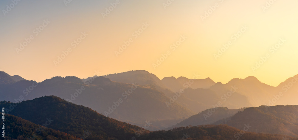 Mountain peak with in sunset sky, panoramic mountain range in sunset light.