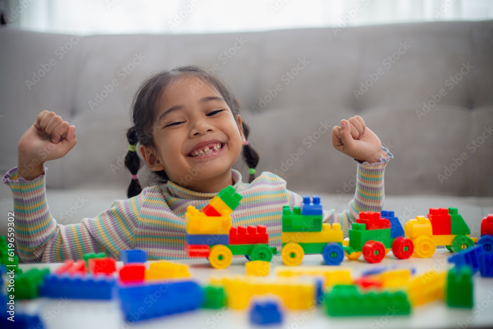 Adorable little girl playing toy blocks in a bright room. Adorable little girl playing toy blocks in a bright room.
