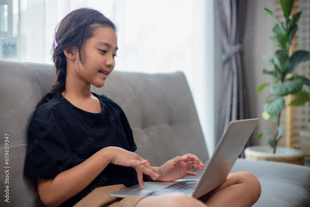 Happy girl learning the English language online with a laptop at home. Happy girl learning the English language online with a laptop at home.
