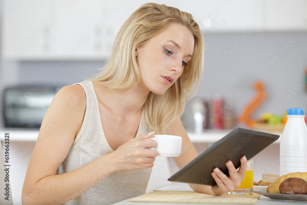 beautiful young woman holding digital tablet in the kitchen beautiful young woman holding digital tablet in the kitchen