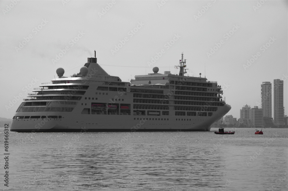 Luxury Silver cruiseship cruise ship liner Spirit or Muse arrival into port of Cartagena de Colombia during Latin America Caribbean cruise with tug boat, pier and city skyline